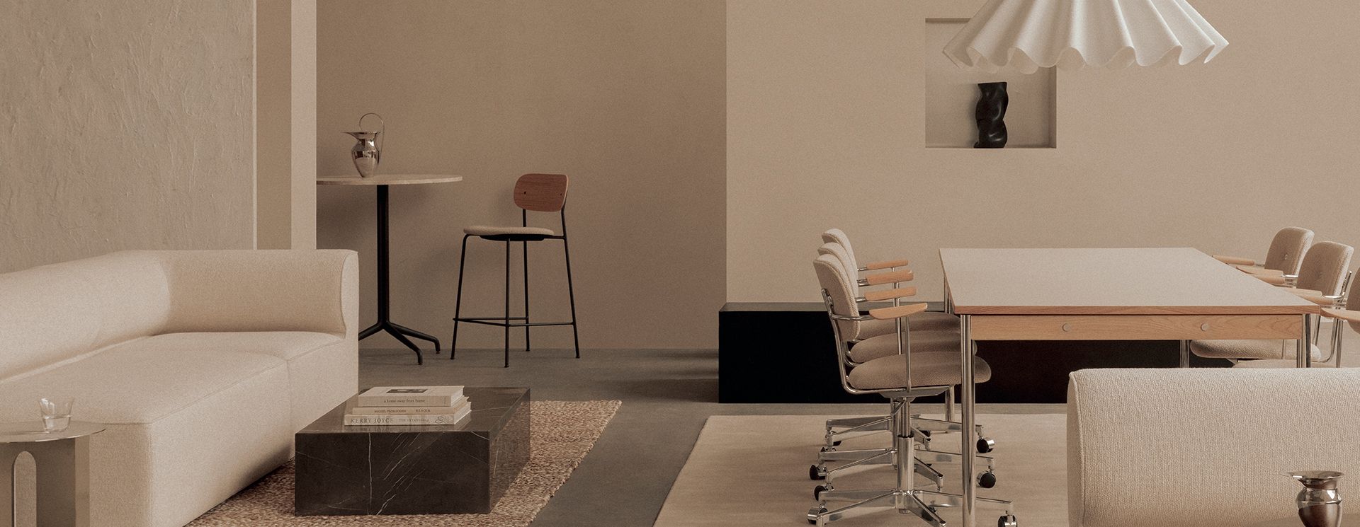 A Living showroom floor: pale sofas, dining tables and task chairs beneath white pendant lamps.