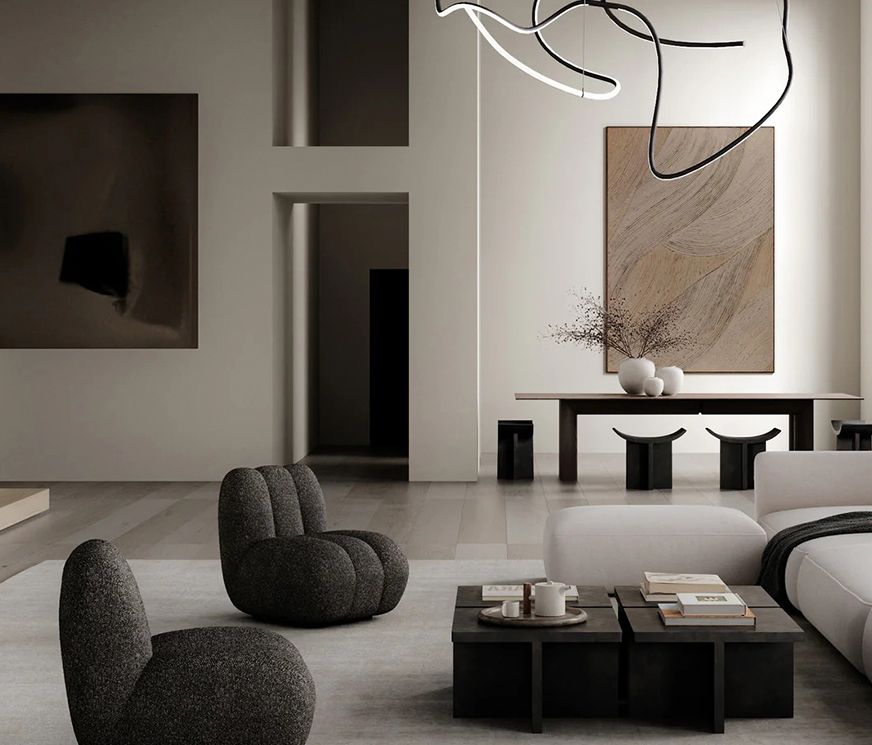 A Living interior: bouclé lounge chairs and low stone tables in a plastered room with arched openings.